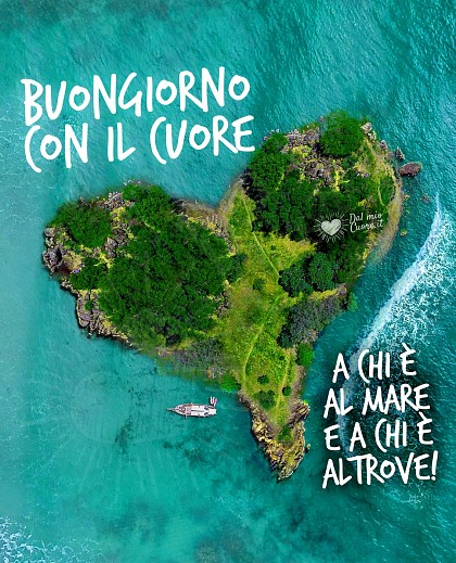 Mare turchese cristallino con isolotto a forma di cuore e la scritta Buongiorno con il cuore. A chi è al mare e a chi è altrove.